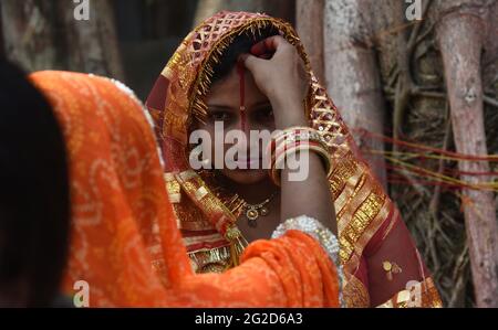 Guwahati, Guwahati, Indien. Juni 2021. Verheiratete Frauen der Bihari-Gemeinschaft stellen sich am Donnerstag, den 10. Juni 2021, in Guwahati Assam India, in der Nähe eines Banyan-Baumes Sindor auf den Vorderkopf. MwSt. Savitri puja ist ein Hindu-Festival, das von der indischen Bihari-Gemeinschaft zum wohl ihres Mannes aufgeführt wird.Quelle: Dasarath Deka/ZUMA Wire/Alamy Live News Stockfoto