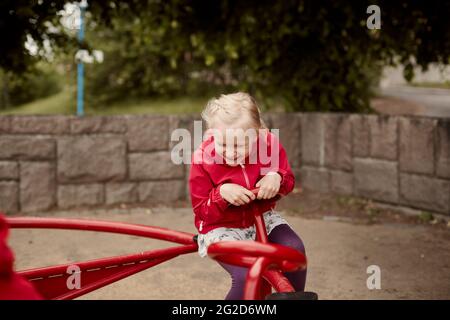 Mädchen dreht sich auf fröhliche Runde gehen Stockfoto