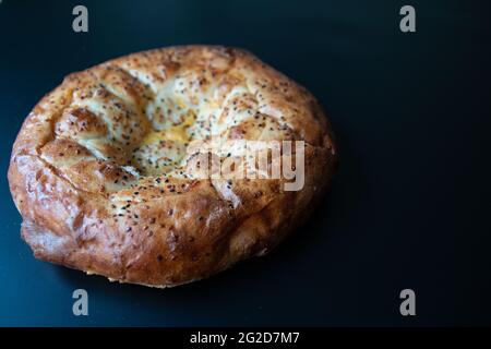 Traditionelles, berühmtes türkisches Brot-Foto, das im heiligen Monat Ramadan gebacken wurde und in der Türkei als „Pide“ bekannt ist. Isolierte runde Pizza mit Sesam. Fladenbrot Stockfoto