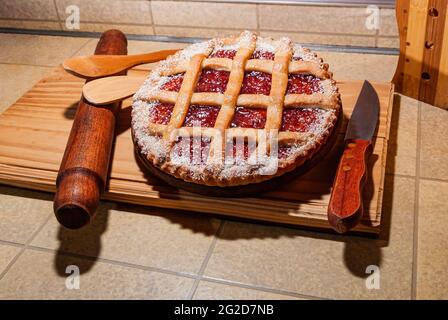 Nahaufnahme einer warmen, hausgemachten Pasta Frola Tarte, gefüllt mit Quitte und Apfelgelee. Argentinische Pastafrola Rezept auf Holztisch. Stockfoto