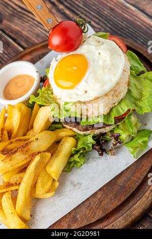 Koreanischer Burger mit Ei, Reis und frittierten Pommes auf Holzgrund Stockfoto