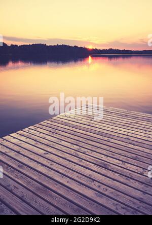 Holzsteg bei goldenem Sonnenuntergang, selektiver Fokus, Farbtonung aufgetragen, Strzelce Krajenskie, Polen. Stockfoto