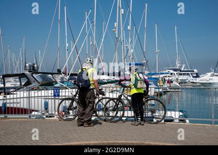 Yarmouth, Isle of Wight, England, Großbritannien. 2021. Ältere Radfahrer, die den Hafen von Yarmouth auf der Nordseite der Isle of Wight überblicken, eine beliebte RE Stockfoto