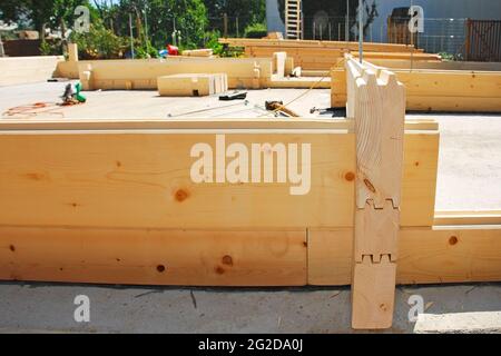 Ein teilweise konstruiertes Holzhaus (Tanne) aus vorgefertigtem Block auf einer inländischen Baustelle. Der Eingang der Vordertür befindet sich vorne rechts. Udine, Italien Stockfoto