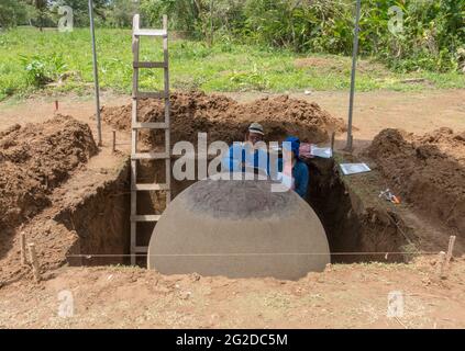 Archäologen des National Museum of Costs Rica untersuchen eine Steinkugel auf der Finca 6 in der Nähe von Palmar Sur, Costa Rica. Stockfoto