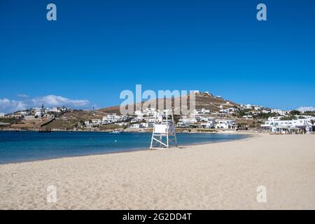 Mykonos Island, Kykladen. Griechenland. Sandstrand von Ornos leer, Platz, Sommerreiskarte und Anzeigenvorlage. Hintergrund des klaren blauen Himmels. Weiß BU Stockfoto