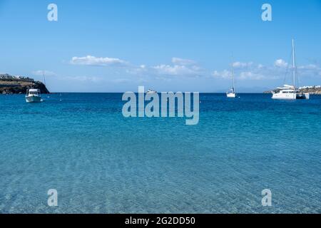 Mykonos Island, Kykladen. Griechenland. Ornos Sandstrand, Sommerurlaub Konzept. Segelboote und Yachten liegen auf offenem Meer, blauer Himmel im Hintergrund. Segeln Stockfoto
