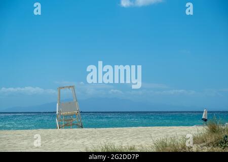 Sandstrand und geriffelte Meereshintergrund, Rettungsschwimmer Turm auf weißem, sauberem Sand. Leerer Strand, Platz für Sommerurlaubs-Karte und Werbevorlage. M Stockfoto