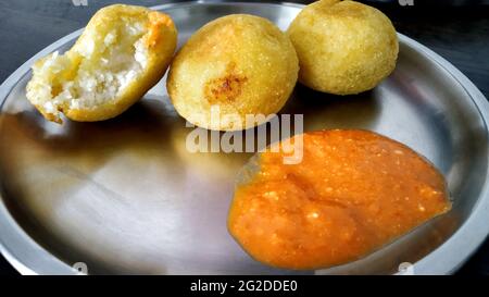 aloo Bonda oder Aloo Pakora serviert mit Sauce auf einem Teller Stockfoto