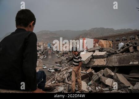 Taiz Jemen - 22. Aug 2016 : Jemenische Kinder sitzen auf den Trümmern ihres zerstörten Hauses, das durch den Krieg in der Stadt Taiz zerstört wurde. Stockfoto