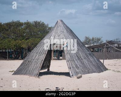 Uribia, La Guajira, Kolumbien - Mai 29 2021: Ökologische Regenschirme aus getrockneten Bananenblättern und Baumstäben am Strand von Mayapo, Kolumbien Stockfoto