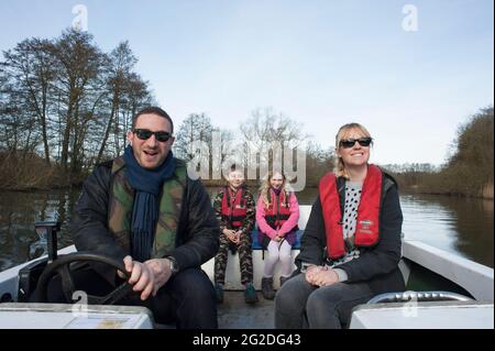 Eine Familie genießt einen Tag auf einem gemieteten Boot auf den Norfolk Broads. Stockfoto