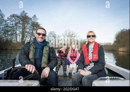 Eine Familie genießt einen Tag auf einem gemieteten Boot auf den Norfolk Broads. Stockfoto