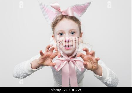 Ein junges Mädchen, das sich für den Weltbuchtag in einem Katzenkostüm verkleidet hat. Stockfoto