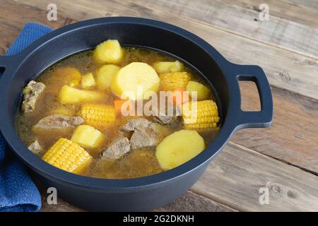 Kolumbianischer Sancocho frisch in einem Topf auf einem Holzboden zubereitet. Speicherplatz kopieren. Stockfoto
