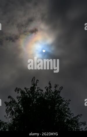 Partielle Sonnenfinsternis schoss um 11:00 Uhr am 10.06.2021 zwischen Wolkenbedeckung in West Sussex, England. Stockfoto