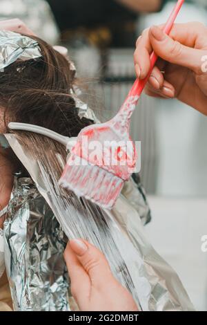 Frau färbt ihre Haare in einem Friseurladen, den Prozess des Färbens ihr Haar mit Folie. Neu Stockfoto