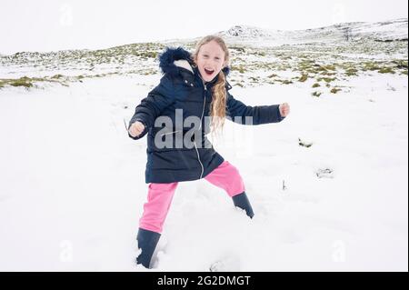 Eine Familie hat Spaß im kalten Schnee, der sich auf dem Boden niedergelassen hat. Stockfoto