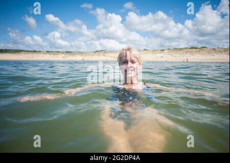 Eine Person, die im Urlaub in Frankreich im Wasser schwimmend ist. Stockfoto