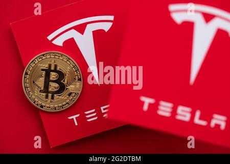 LONDON, Großbritannien - 2021. Juni: Bitcoin-Kryptowährung auf einem Tesla-Elektrofahrzeug-Logo Stockfoto