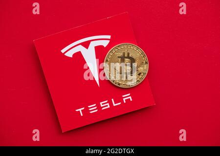 LONDON, Großbritannien - 2021. Juni: Bitcoin-Kryptowährung auf einem Tesla-Elektrofahrzeug-Logo Stockfoto