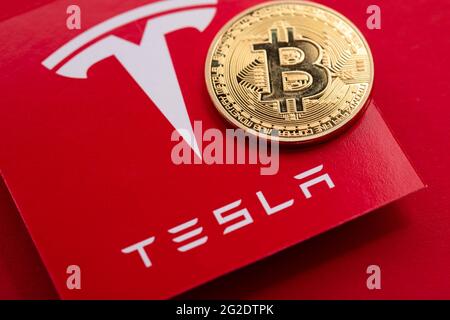 LONDON, Großbritannien - 2021. Juni: Bitcoin-Kryptowährung auf einem Tesla-Elektrofahrzeug-Logo Stockfoto