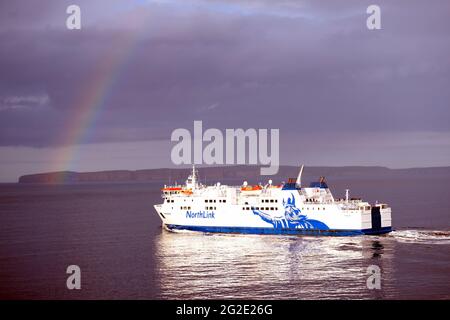 VEREINIGTES KÖNIGREICH; REGENBOGEN ÜBER DER NORTHLINK FÄHRE 'HAMNAVOE' EN ROUTE ZU DEN ORKNEY INSELN VON SCRABSTER Stockfoto