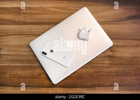 Weißrussland, Minsk Region - 17. März 2020: Set von Apple Gadgets: Laptop, iphone und airpods auf Holztisch Hintergrund. Stockfoto