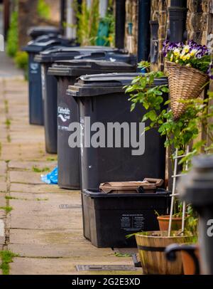 Vor den Häusern in West Yorkshire, Hebden Bridge, Großbritannien, standen Wheely Mülltonnen Stockfoto