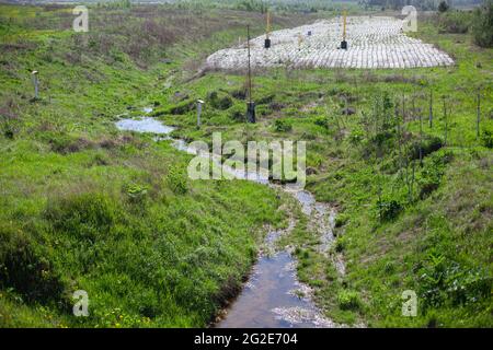Wasserablauf. Neigung, um Wasser von der Straße abzuleiten. Hydrokommunikation entlang der Autobahn. Betonabfluss. Graben zum Schutz vor Regen. Stockfoto