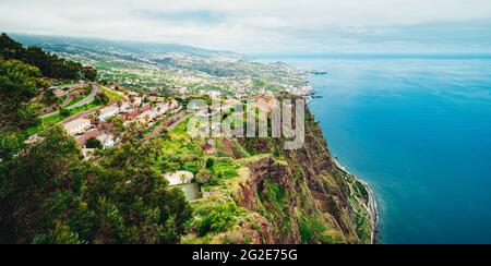 Vertikale Aufnahme von Cabo Girao hohe Klippe in der Nähe des Meeres auf der Insel Madeira, Portugal unter einem bewölkten Himmel Stockfoto