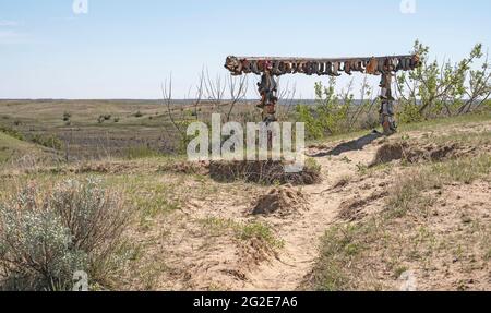 Alte Cowboystiefel wurden in den Great Sandhills (Sand Hills) in der Nähe von Scepter, Saskatchewan, Kanada, an eine Schiene genagelt Stockfoto