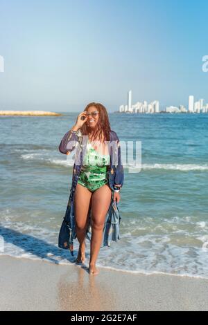 Afroamerikanische Frau genießt Freizeit im Freien in der Nähe des Ozeans am Strand. Fröhlicher Tourist in den Tropen. Stockfoto