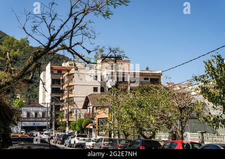 Wohngebäude an den Straßen des Higino da Silveira Platzes mit vielen Autos, die in der Nähe unter sonnenklarem, blauem Himmel geparkt sind. Stockfoto