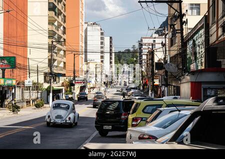 Südansicht des sehr langen absteigenden Abschnitts der Oliveira Botelho Avenue mit geparkten Autos, in der Nähe Nilo Pecanha Platz unter sonnigen klaren blauen Himmel Tag. Stockfoto