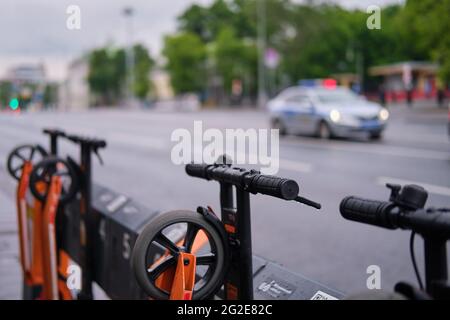 Motorroller Verleih und Polizisten auf der Straße - Moskau, Russland, 10. Juni 2021 Stockfoto