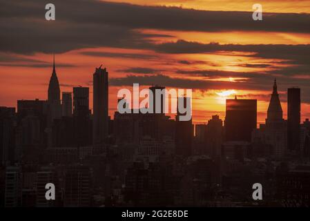 10. Juni 2021 partielle Sonnenfinsternis über der Skyline von NYC bei Sonnenaufgang Stockfoto