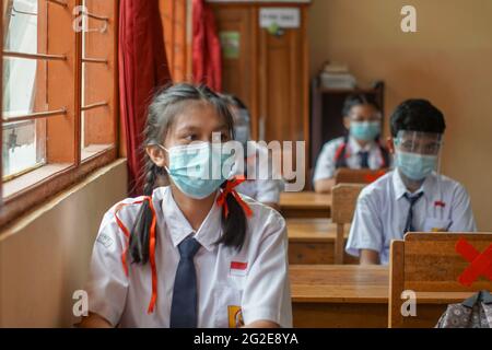 BALI, INDONESIEN-MAI 18 2021: Studenten in Indonesien verfolgen den Lernprozess im Unterricht mit Gesichtsschutz und Gesundheitsmasken, um Gesundheit p zu implementieren Stockfoto
