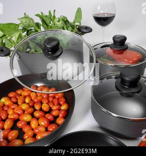 küchengeräte – Set aus antihaftbeschweißten Töpfen mit Glasdeckel; Foto auf weißem Hintergrund. Stockfoto