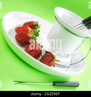 Keramikbehälter mit Utensilien für Fondue. Stockfoto