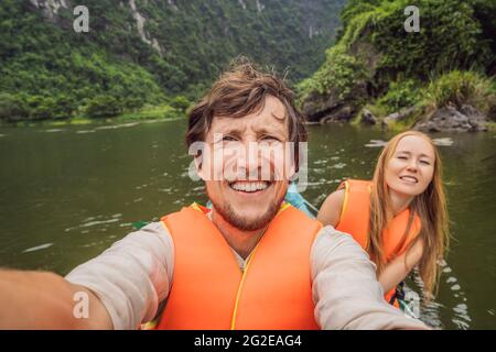 Glückliche Familien-Touristen in Trang an Scenic Landscape Complex in Ninh Binh Provinz, Vietnam EIN UNESCO-Weltkulturerbe. Wiederaufnahme des Tourismus in Stockfoto