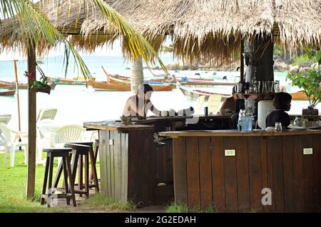 Menschen unter dem Strohdach der Insel Stockfoto