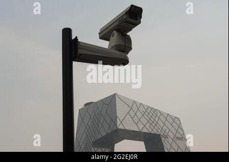 16.08.2012, Peking, China, Asien - EINE Überwachungskamera und das neue Gebäude des CCTV-Hauptquartiers in der chinesischen Hauptstadt. Stockfoto