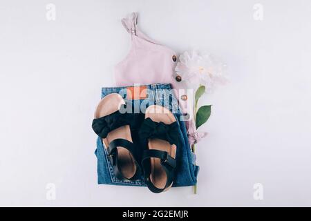 Sommerliches Mode-Outfit - Oberteil, Denim-Shorts, schwarze Sandalen. Weibliche Reise Urlaubskleidung. Flach liegend Stockfoto