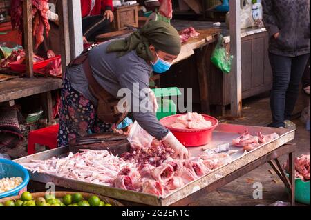 Eine kambodschanische Rohstoffverkäuferin, die während der Coronavirus-Pandemie eine Gesichtsmaske/Abdeckung trägt. Kandal Market, Phnom Penh, Kambodscha. März 2020. © Kraig Lieb Stockfoto