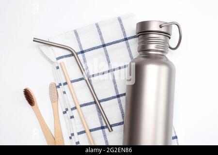 Trinkflasche und wiederverwendbare Trinkhalme aus Edelstahl mit Bambus-Zahnbürsten. Zero Waste Konzept. Stockfoto