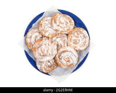 Teller mit typisch spiralförmigem Ensaimadas-Gebäck von der Baleareninsel Mallorca, Spanien. High-Angle-Ansicht, isoliert auf weißem Hintergrund Stockfoto