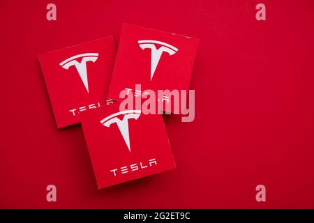 LONDON, Großbritannien - Juni 2021: Tesla-Elektrofahrzeug und Clean Energy-Logo Stockfoto