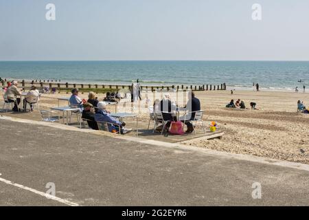 Menschen, die einen Sandstrand und ein Café in Littlehampton, West Sussex, England, genießen. Sozial distanziert aufgrund von Covid 19-Beschränkungen. Stockfoto