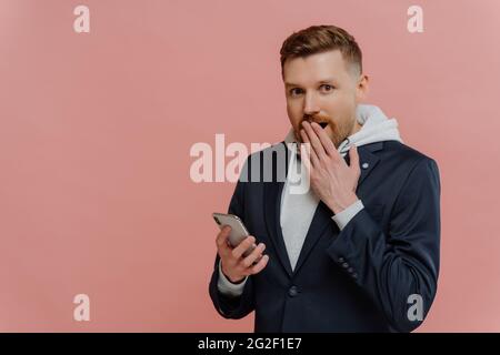 Junger Mann erhält schockierende Nachricht auf dem Smartphone Stockfoto